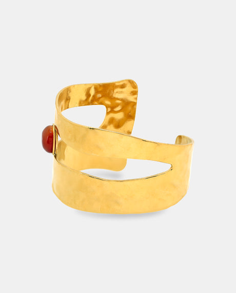 Brazalete ancho en acero dorado con lineas abiertas y piedra roja-granate.
