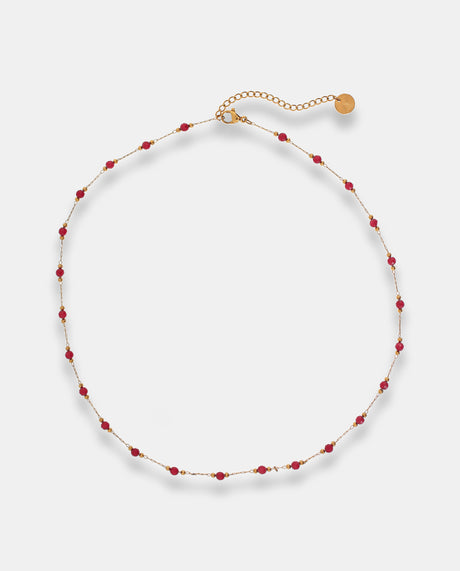 Collar en acero dorado con pequeñas cuentas rojas.