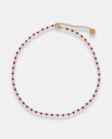 Collar en acero dorado  con piedras rojas.