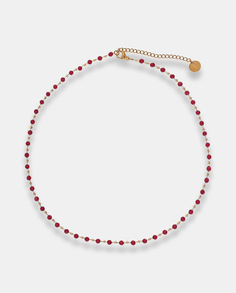 Collar en acero dorado  con piedras rojas.