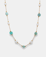 Collar en acero dorado con piedras verdes irregulares y pequeñas piedras blancas.
