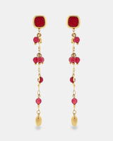 Pendientes largos en acero dorado con piedras rojas.