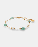 Pulsera en acero dorado con piedras  verdes irregulares y  blancas redondas.