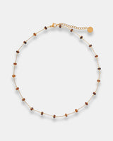 Collar en acero dorado con cilindros de resina.