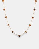 Collar en acero dorado con cilindros de resina.